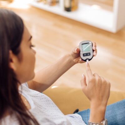 Young woman using glucometer